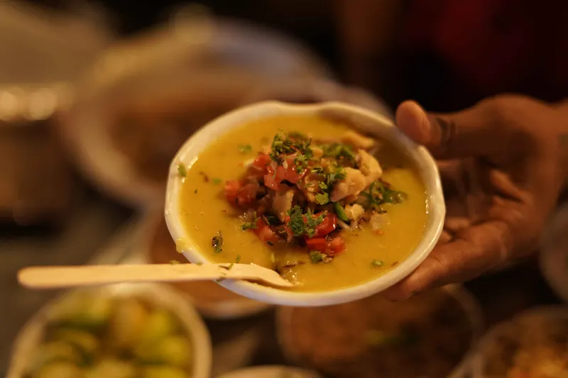 Freshly served bowl of curry garnished with coriander and chilli