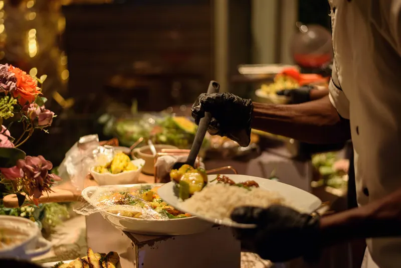 Buffet spread being served with chafing dishes and rice preparations