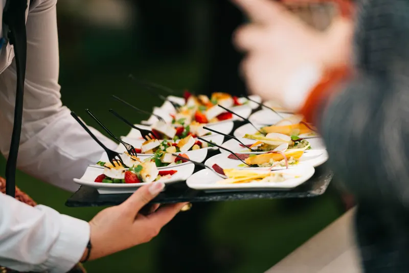 Server carrying a platter of canapés at a corporate event