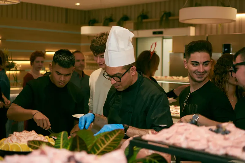 Chefs preparing and plating dishes in a professional catering kitchen