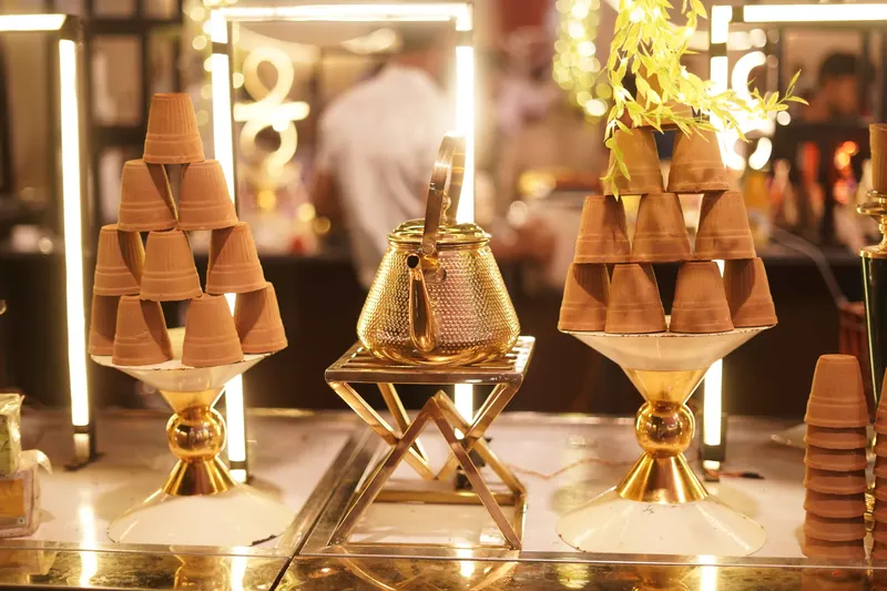 Dessert station with stacked clay cups on gold stands at a private party