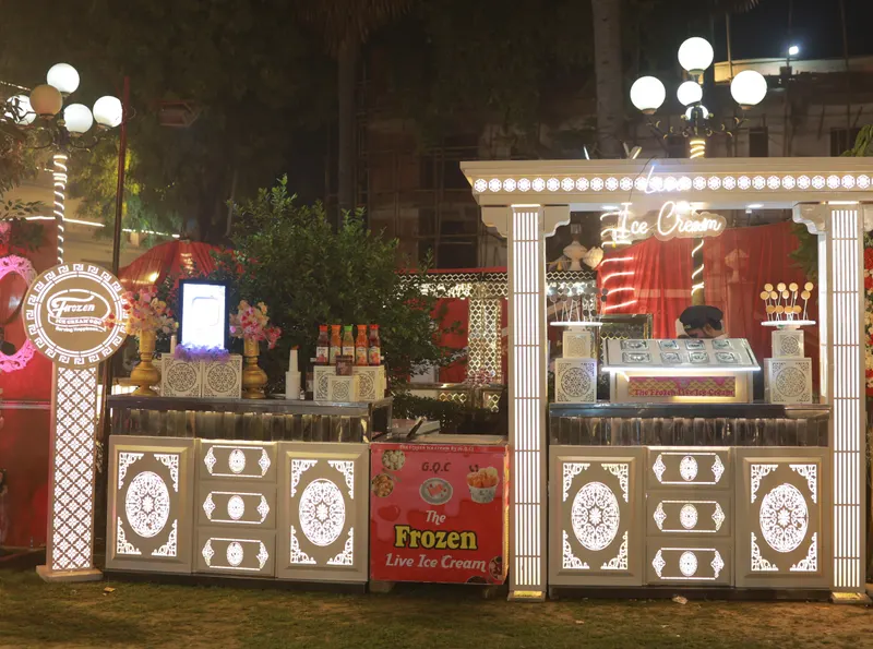 Illuminated live ice cream stall serving rolled ice cream at an outdoor function